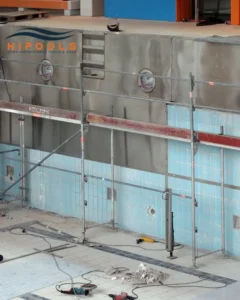 Construction workers carefully placing steel walls during the installation of an inground swimming pool