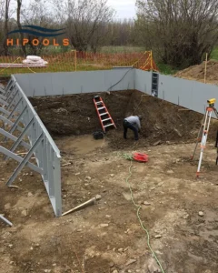 Excavation work being done on a backyard to prepare for an inground swimming pool installation