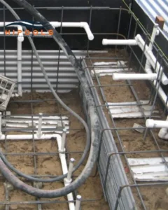 Plumbers installing pipes and equipment necessary for water circulation in a newly constructed swimming pool.