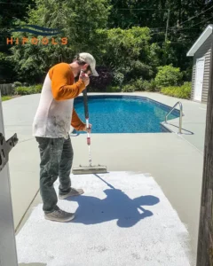 Workers adding finishing touches around a newly installed swimming pool before it is filled with water.