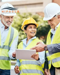 A professional team of pool builders discussing plans at a construction site in Atlanta